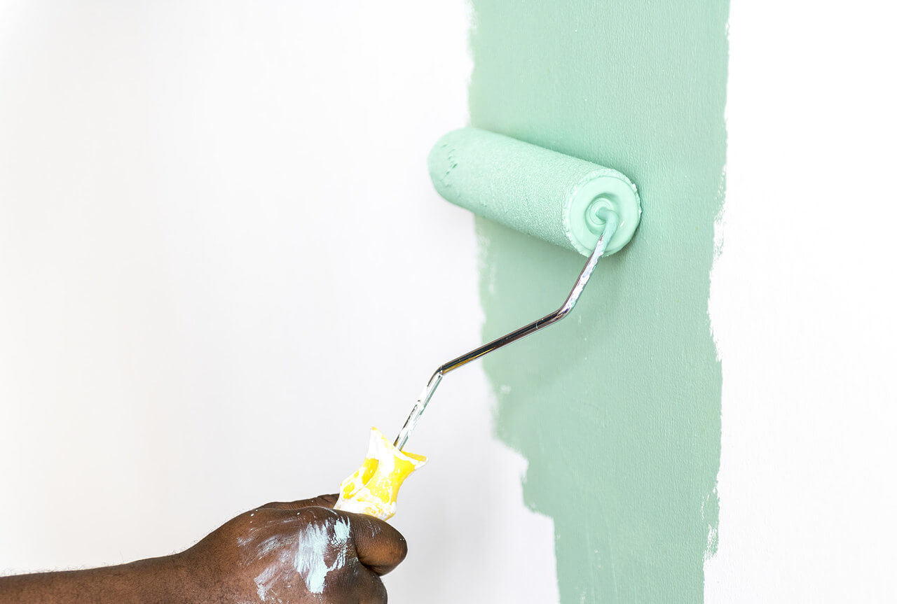 Pessoa pintando parede de azul